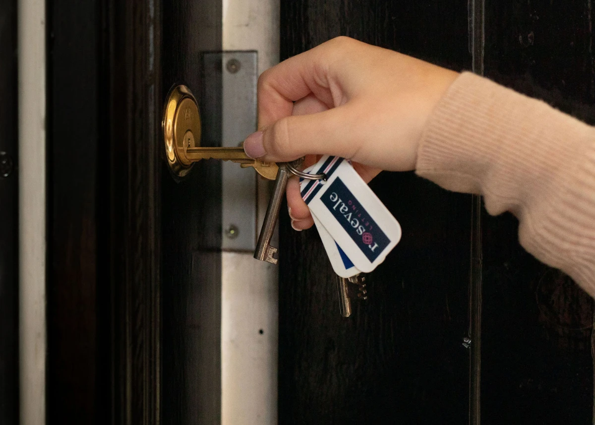 A header image of the What does let agreed mean post. Featuring a hand holding a key to a door lock